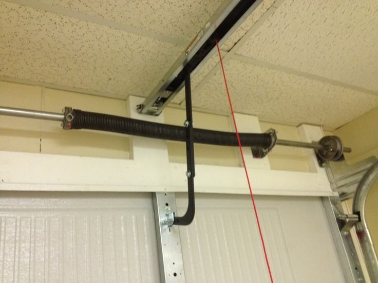 High tension garage door spring mechanism inside a residential garage tracking configuration