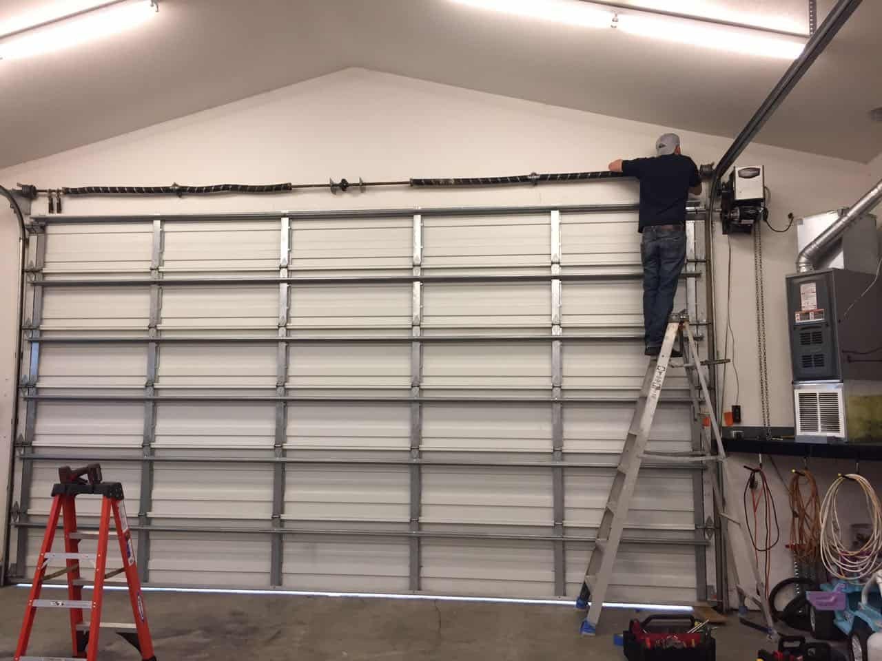 Technical specialist executing detailed garage door repair services on an tracking mechanism