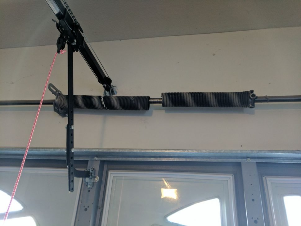 Technician measuring high-tension heavy spring counterweights safely