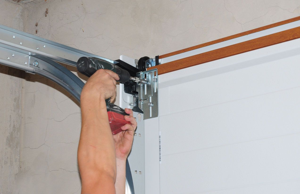 Technician completing a garage door repair job