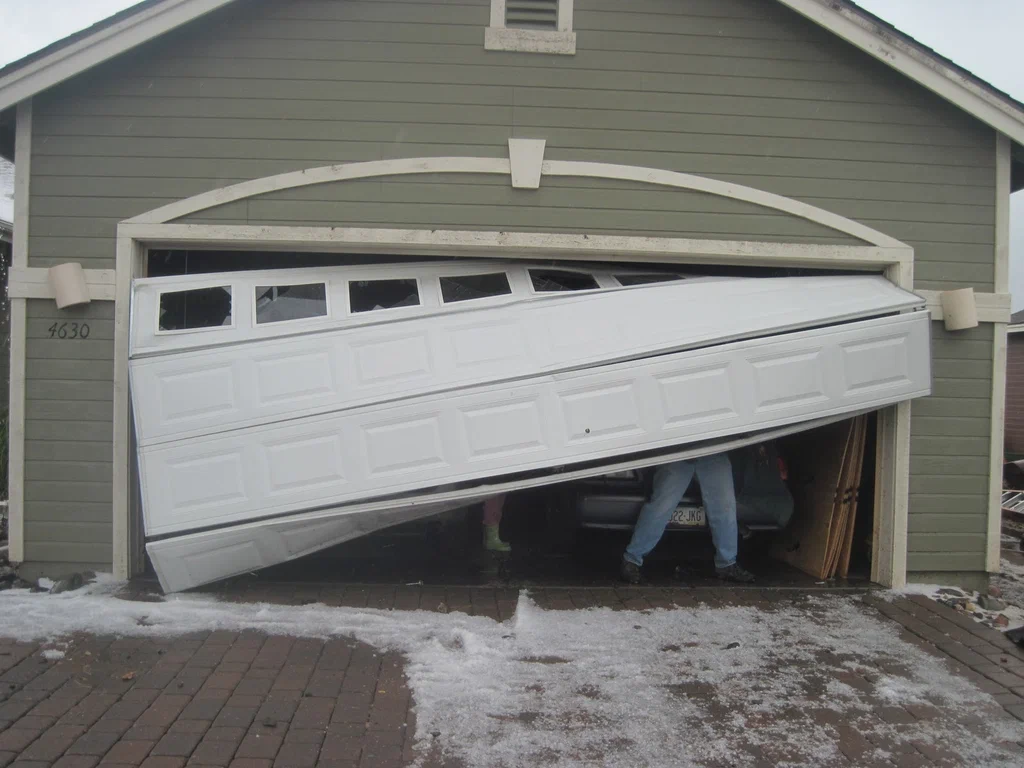 Technician repairing a residential garage door in San Antonio, TX